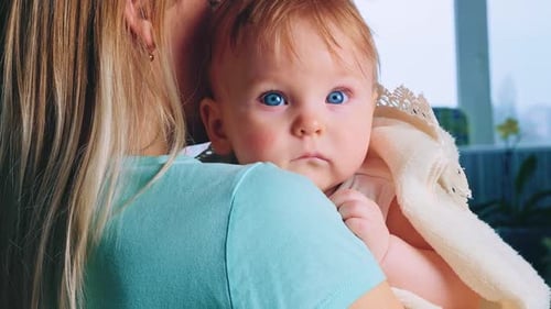 Content Baby in Mother's Arms After Bath