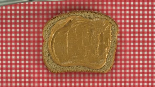 Spreading Peanut Butter and Jelly on Multi-Grain Bread