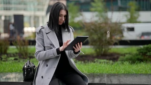 Woman Uses Tablet in Modern Urban Environment