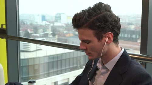 Man with Headphones Listening in City Building