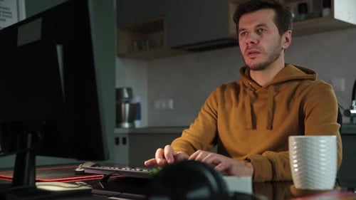 Tired Man Works Late at Workplace in the Night