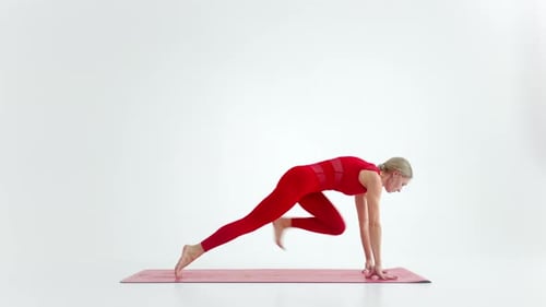 Flexibles Mädchen mit junger Passform, Yoga oder Pilates, führt eine wilde Thing-Pose für Dehnen und Wellness