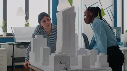 Team of Architects Working with Building Model and Maquette to Plan Construction Layout