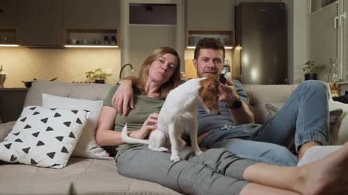 Couple Relaxing on Couch with Dog at Home