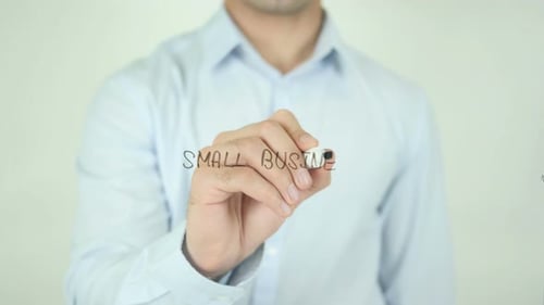 Adult Writes Small Business on Clear Surface