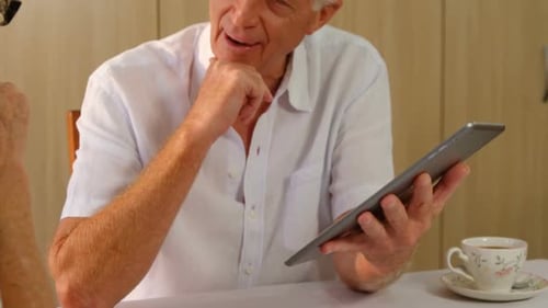 Seniors Talking and Looking at Tablet