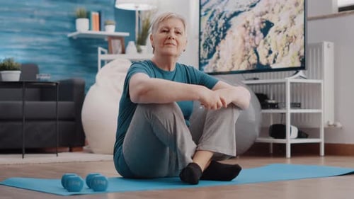 Senior Woman Smiling on Yoga Mat at Home