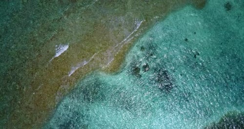 Wide drone tourism shot of a sandy white paradise beach and aqua blue water background in high resol