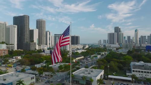 American Flag Waves Over Sunny Cityscape