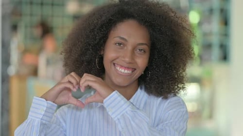 African Woman Showing Heart Sign with Hand