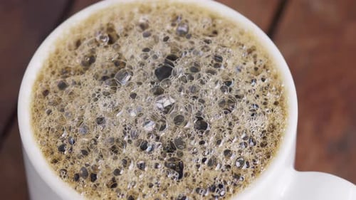 Bubbling Coffee Foam in a White Cup