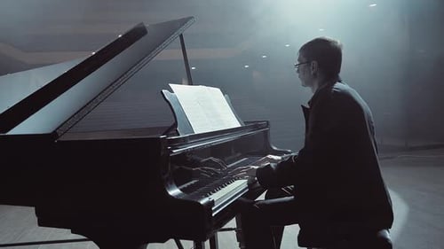 Pianist in Dark Suit Playing on a Grand Piano on Big Stage