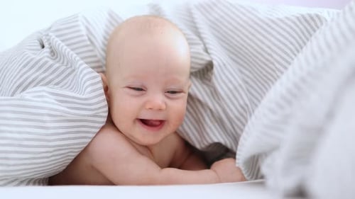 Happy Smiling Infant Baby Portrait Caucasian Blue Eyes Child Lying on Stomach