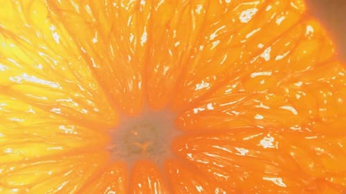 Drop of Water Flows Down the Surface of a Ripe Juicy Orange Slice