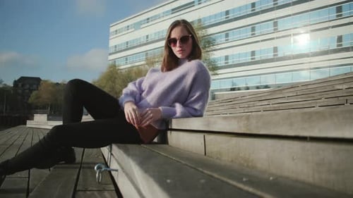 Stylish Woman Sits on Urban Steps in Sunlight