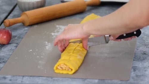 Woman Slicing Delicious Apple Pastry with Kitchen Knife