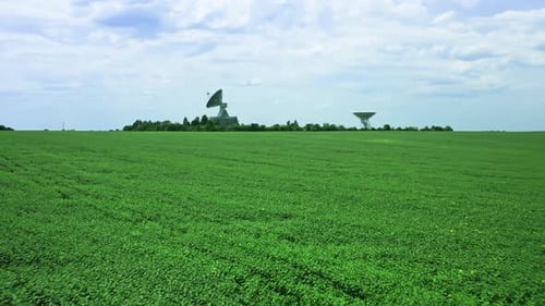 Satellite Dishes Overlooking Green Agricultural Field