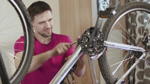 El mecánico aprieta el perno con llave de tubo en el eje del pedalier de la bicicleta