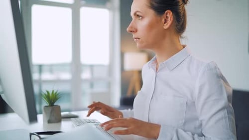 Woman Working at Computer in Bright Office
