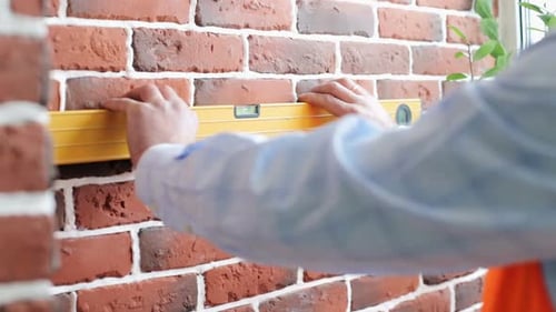 A construction engineer checks the walls with a level.
