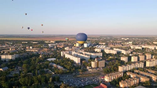 Aerial Drone View of Colorful Hot Air Balloons Flying Over Green Park and Industrial District in
