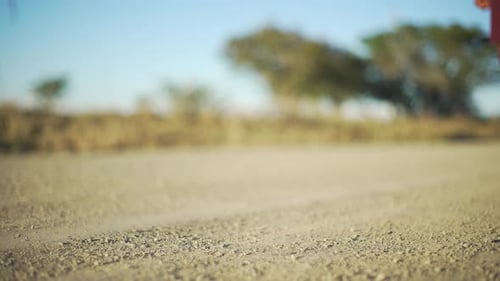 Feet of school girl walking on a gravel road.