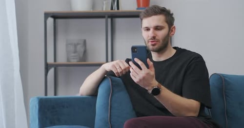 Man Chatting on Phone While Sitting on Couch