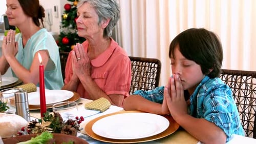 Família extensa pedindo graça antes da ceia de Natal