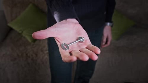 Male Hand Holding a Home Key and Showing It to the Camera CloseUp