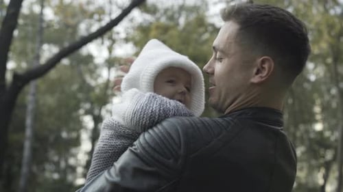 Affectionate Father Holding Adorable Baby in Autumn Park