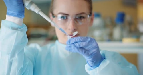 Scientist Handling Pipette in a Laboratory Setting