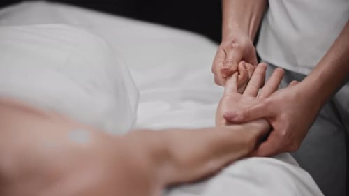 Massage therapist giving hand massage