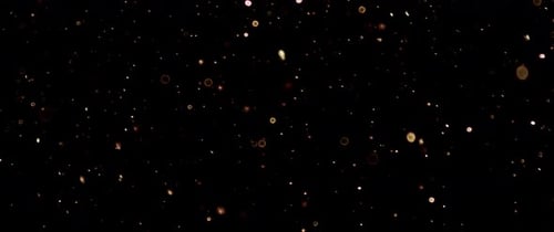 Golden Particles Floating on Black Background