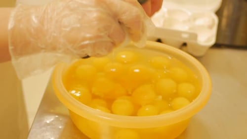 Eggs being cracked into bowl with knife