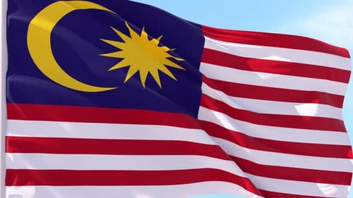 Waving Flag of Malaysia Against Blue Sky
