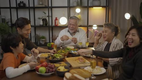 Family Gathering for Festive Meal, Eating and Laughing