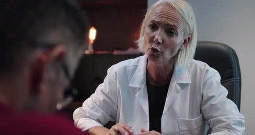 Woman Doctor Explains to Patient in Office