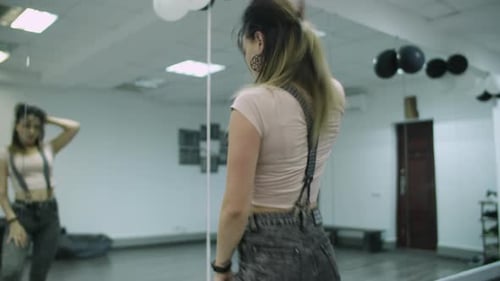 Caucasian female dancer choreographer performing a freestyle dance in dance studio against mirror wa