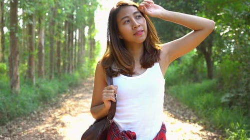 Young Asian woman traveler with backpack walking in forest.Adventure backpacker travel people.