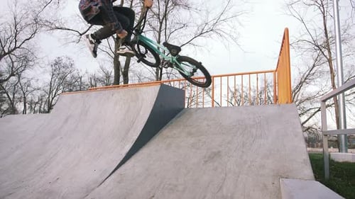 BMX Rider Doing Tricks in Street Plaza Bicycle Stunt Rider in Cocncrete Skatepark Super Slow Motion