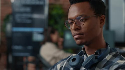 Closeup Portrait of Software Engineer Writing Code Fixing Glasses and Smiling Sitting at Desk