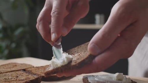 Spreading Cream Cheese on Rye Bread Slices
