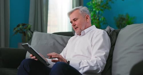 Adult Using Tablet on Couch at Home