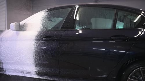 Car Getting Washed With White Soap Foam