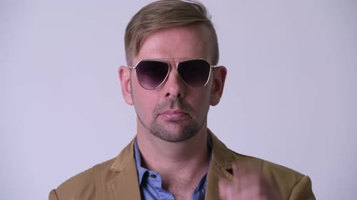 Man Takes Off Sunglasses and Smiles