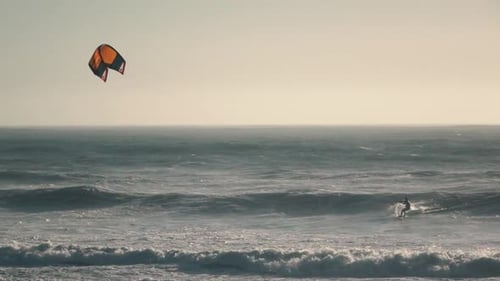 Kitesurfer Rides Ocean Waves on Sunny Day