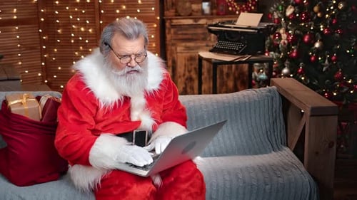 Modern Male Santa Claus Use Laptop at Festive Illuminated Room