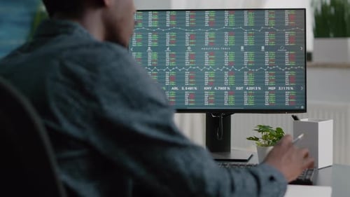 Man Analyzing Stock Market Data on Computer