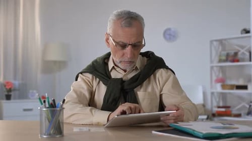 Senior Man Using Tablet in Home Office