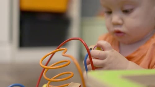 Baby Plays with Colorful Wooden Activity Toy